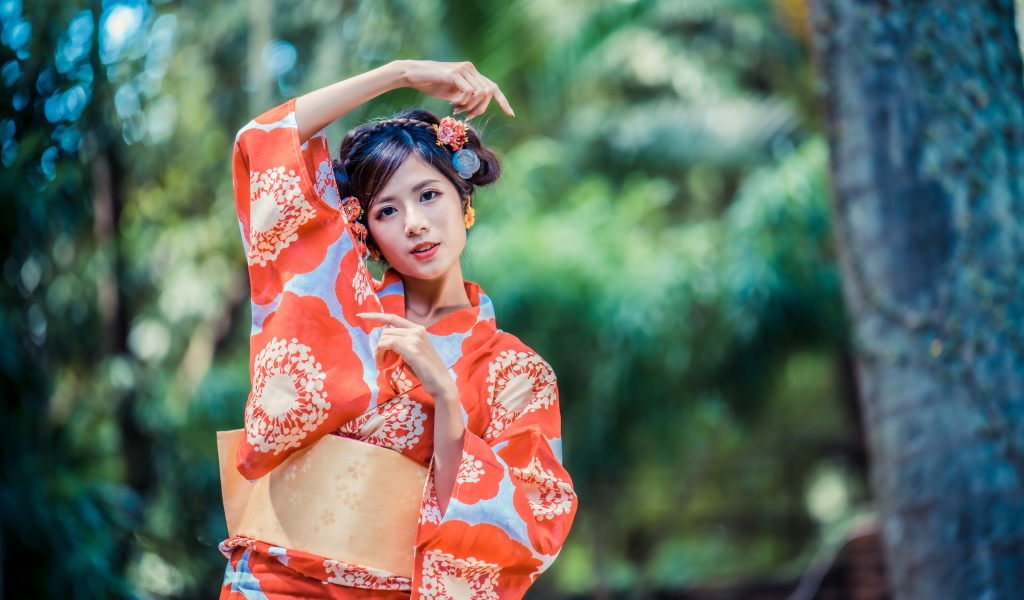 Молодая азиатка в кимоно в парке 