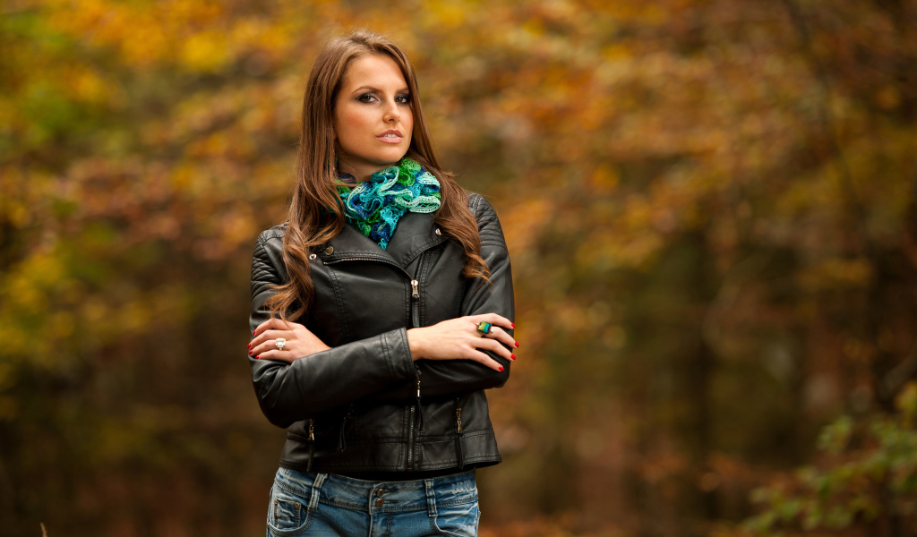Молодая девушка в черной кожаной куртке  в парке
