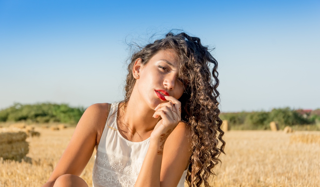 Молодая девушка в белом платье на пшеничном поле