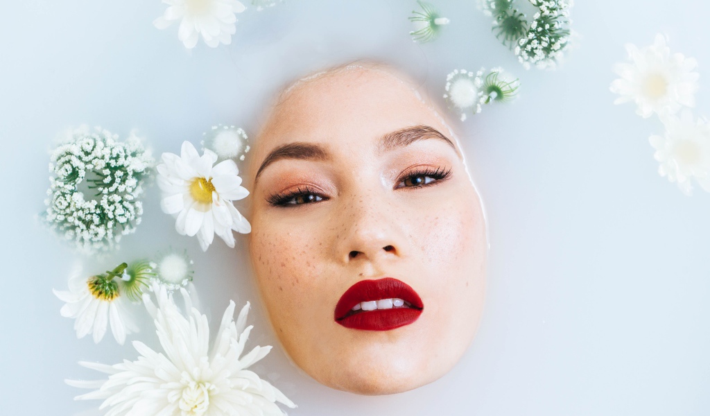 Молодая девушка лежит в ванной с цветами