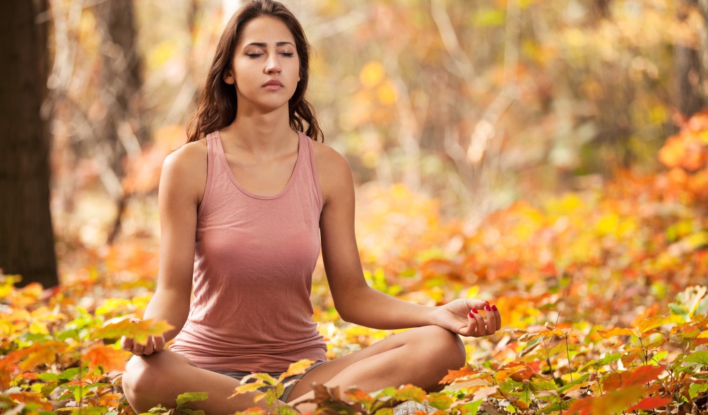 Молодая девушка медитирует в лесу 