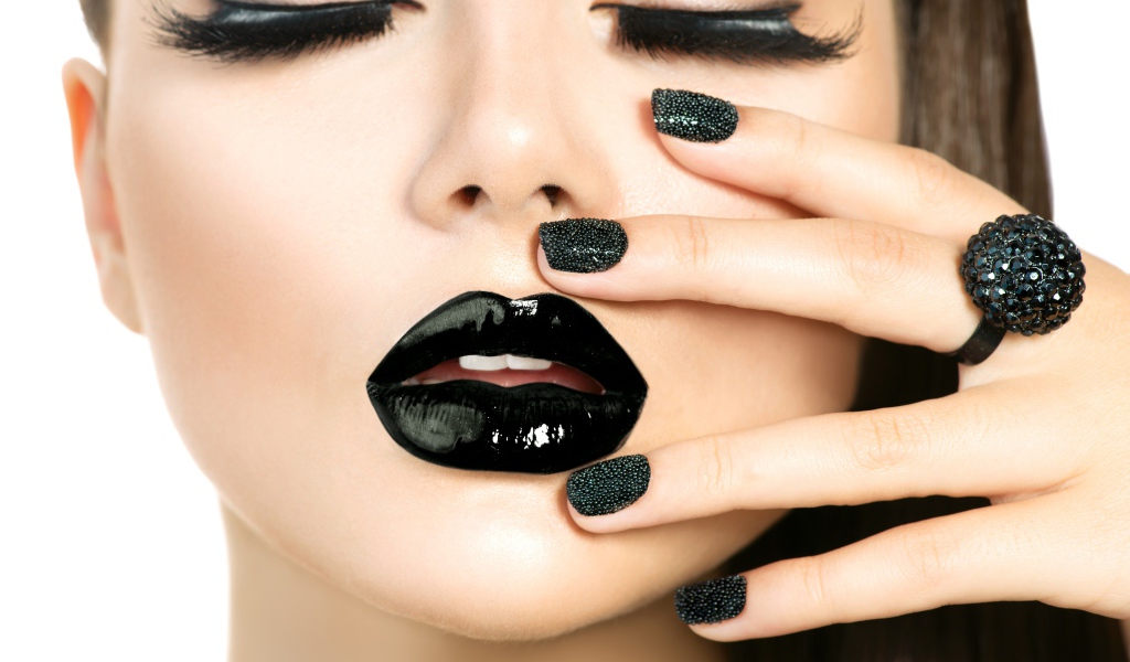 Молодая девушка с черным макияжем на белом фоне