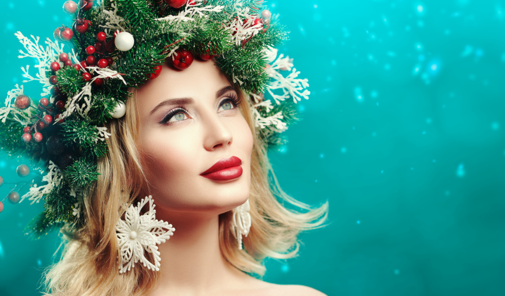 Красивая девушка с венком из еловых веток на голове на голубом фоне