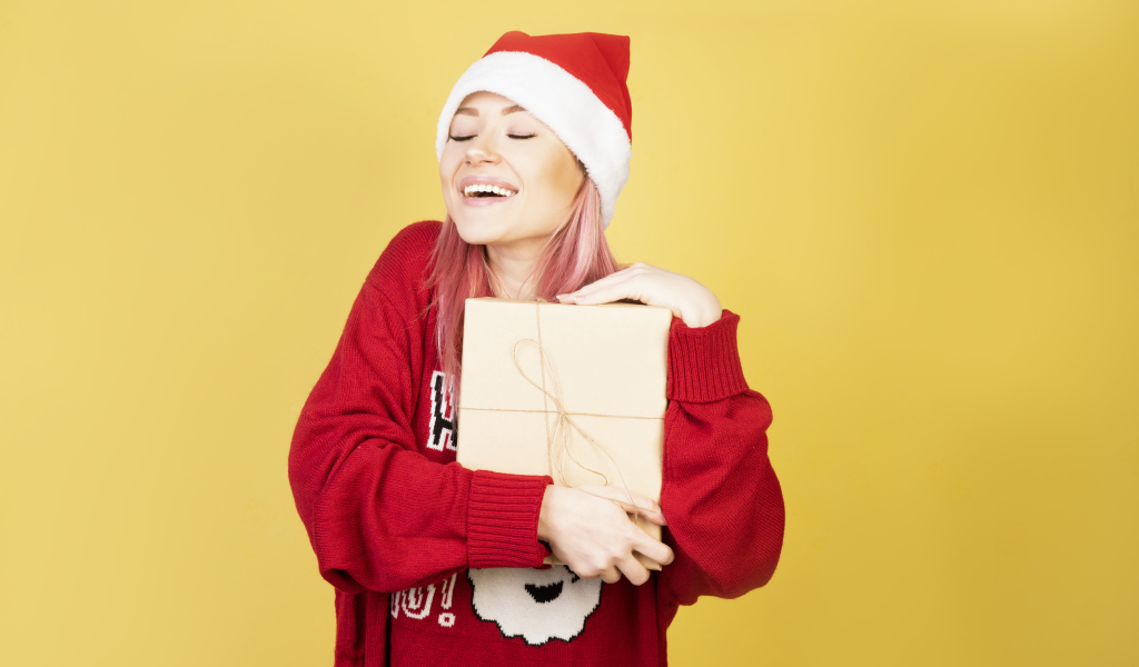 Улыбающаяся девушка в красном свитере с подарком на желтом фоне