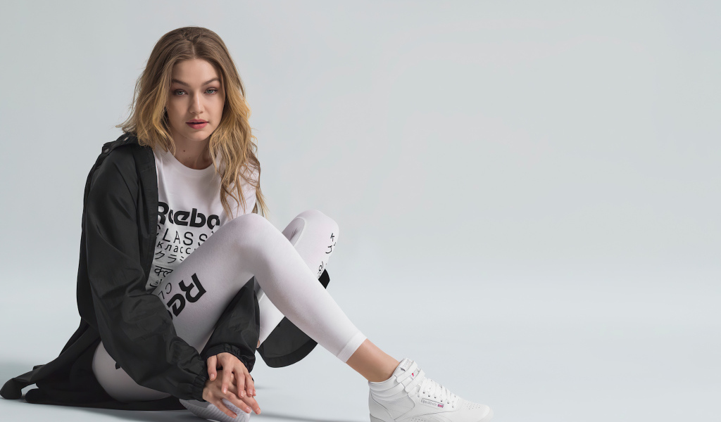 Американская супермодель Джиджи Хадид в спортивном костюме сидит на полу