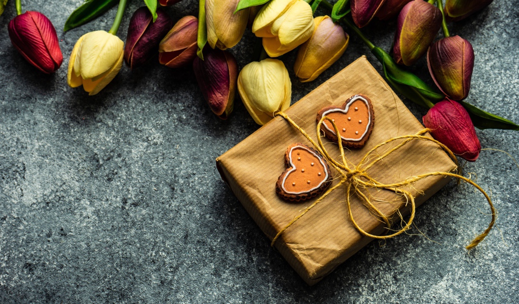 Подарок с букетом тюльпанов на сером столе