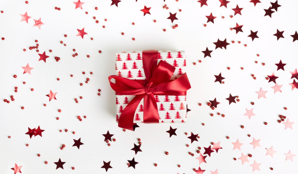 Gift with a red bow on a white background with stars