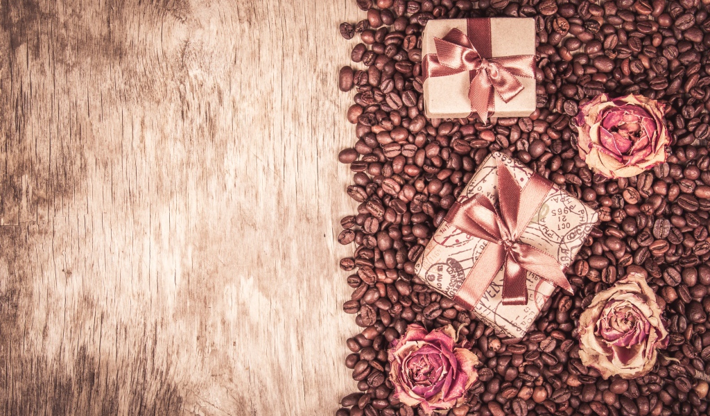 Подарки и розы лежат на кофейных зернах