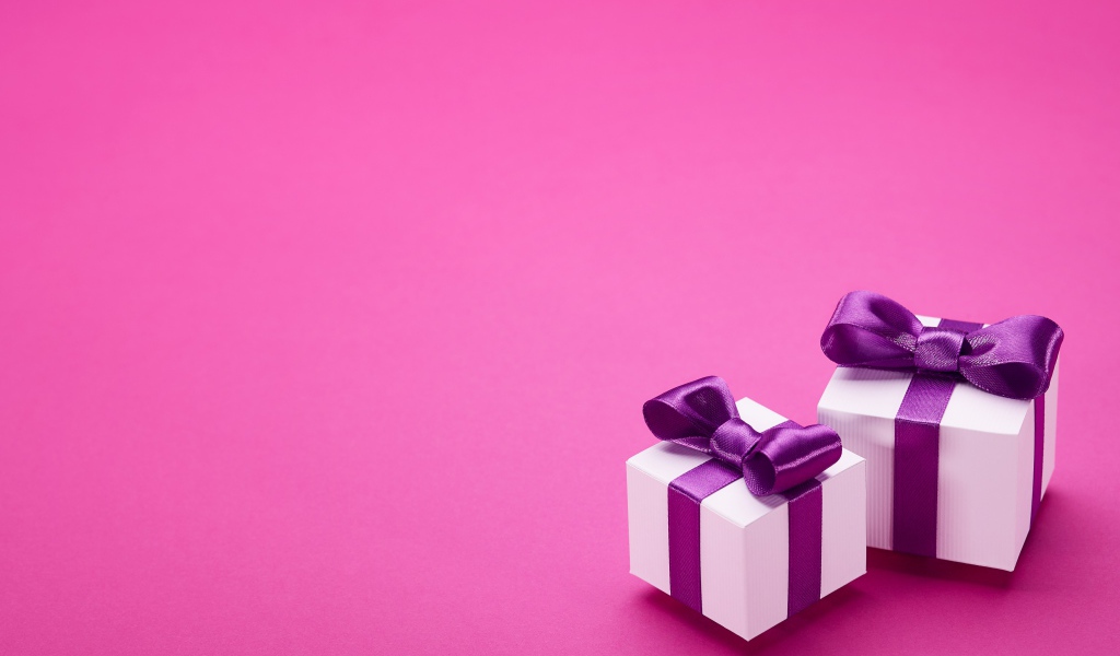 Два подарка с бантами на розовом фоне 