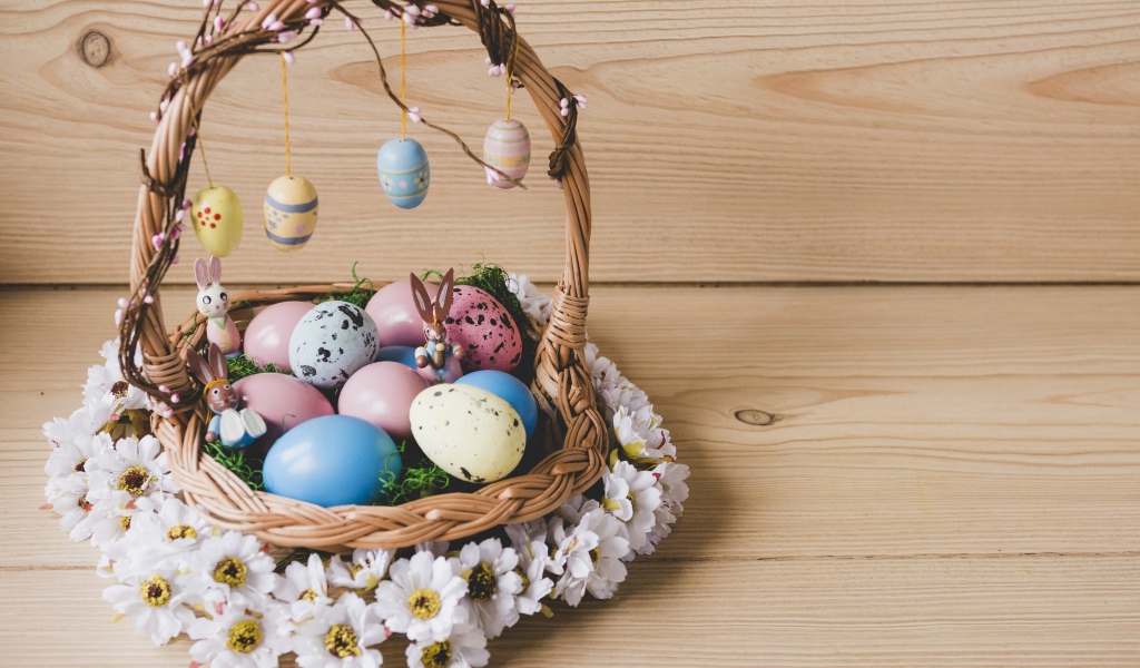 Корзинка с пасхальными яйцами украшена цветами