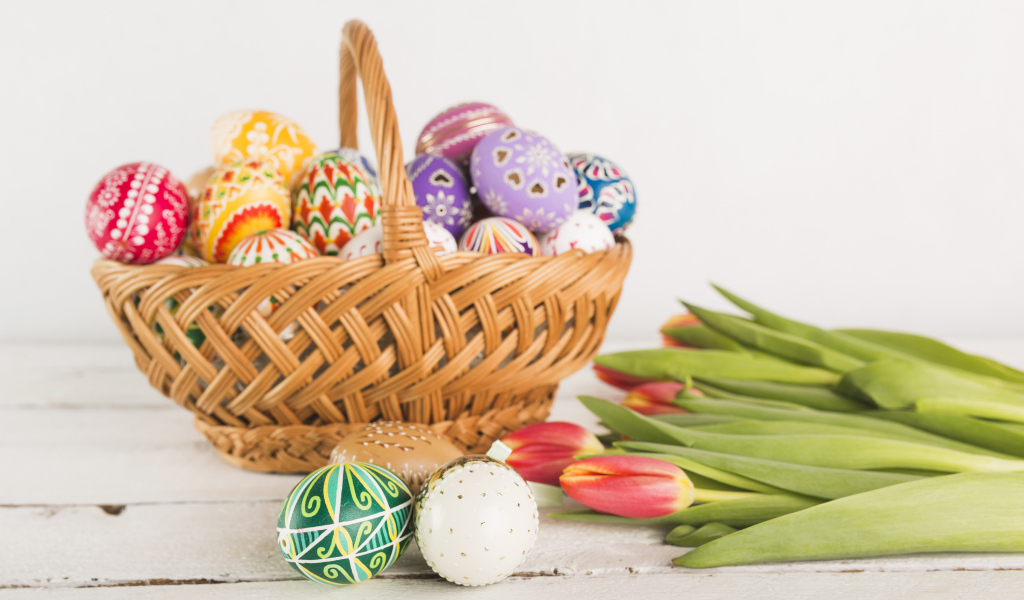 Корзинка с разноцветными яйцами и тюльпанами на Светлый праздник Пасха