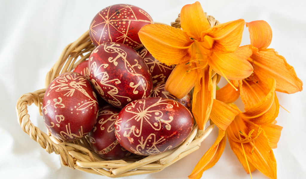Красивые пасхальные яйца с цветами лилии в корзине