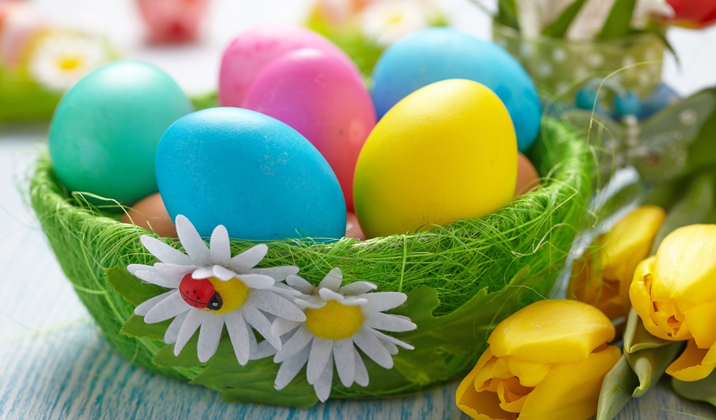 Colorful eggs on a table with tulips for Easter