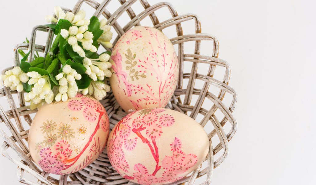 Яйца с рисунком в корзине с цветами на Пасху