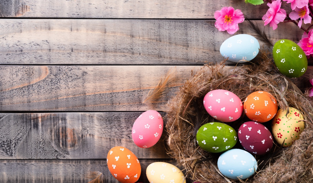 Разноцветные яйца в гнезде на столе на Великий православный праздник Пасха