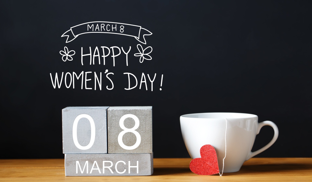 Чашка чая на столе с кубиками на Международный женский день 8 марта