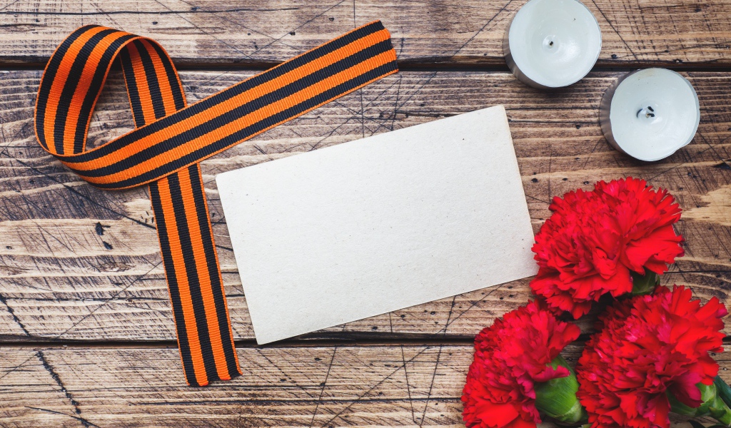 Красные гвоздики, георгиевская лента и свечи на столе, шаблон для открытки на 9 мая День победы