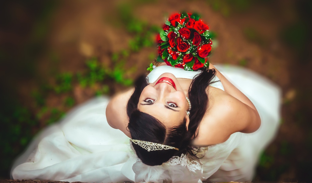 Улыбающаяся девушка невеста с букетом красных роз