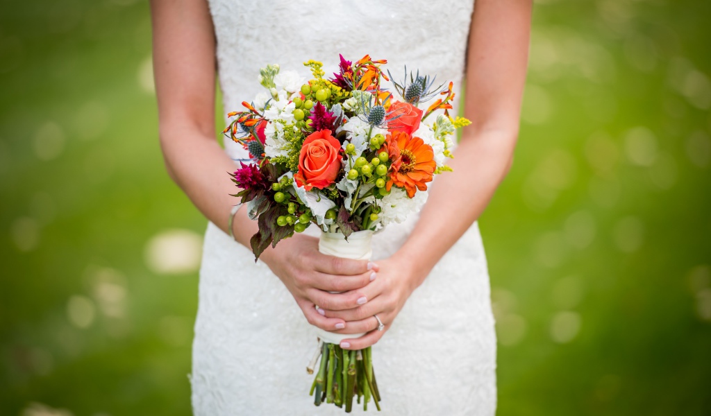 Букет невесты в руках у девушки в белом свадебном платье