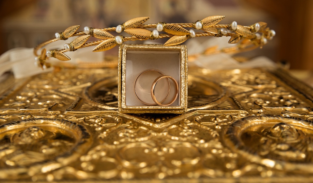 Два золотых обручальных кольца в коробке с венком 