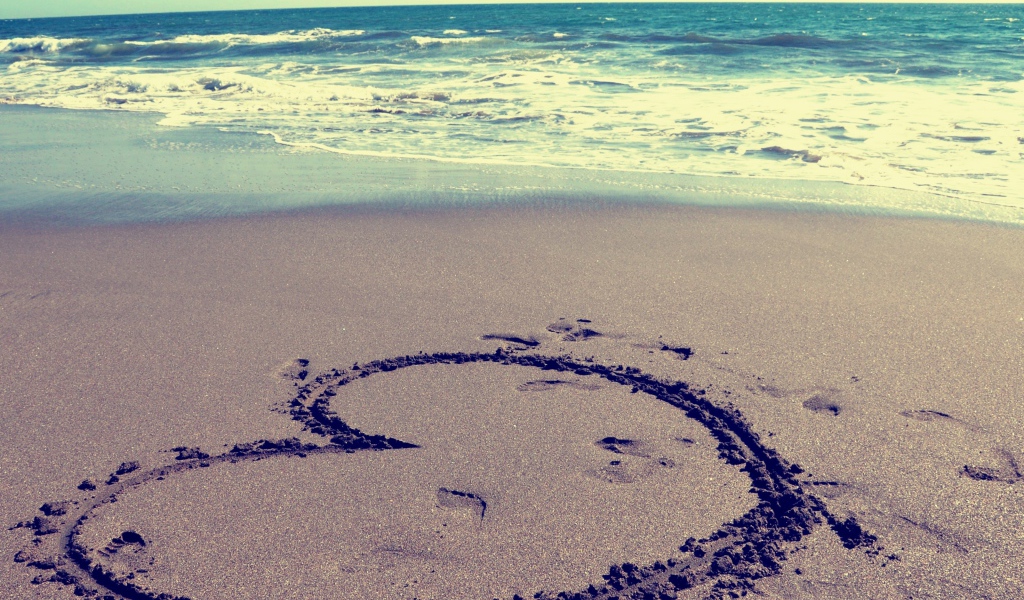 Большое сердце на мокром песке на пляже