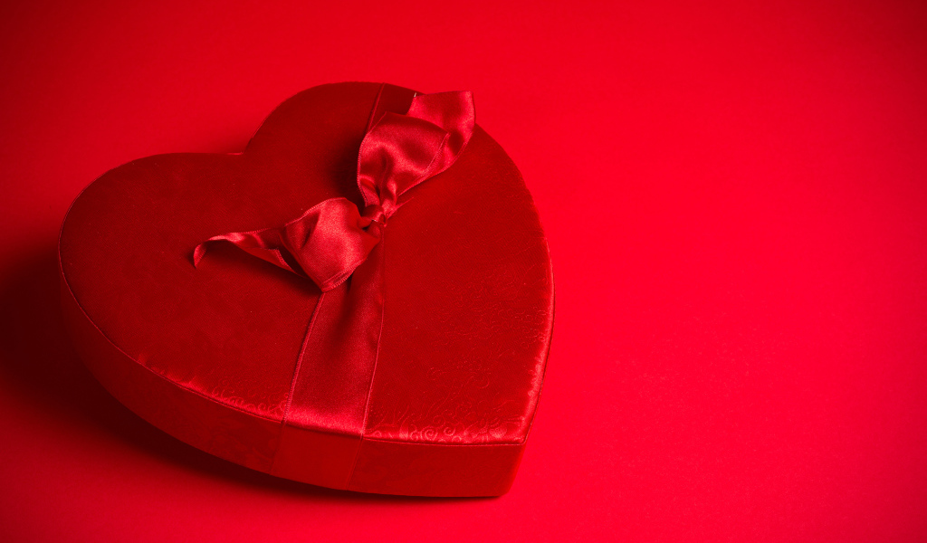 Большое красное сердце с бантом на красном фоне