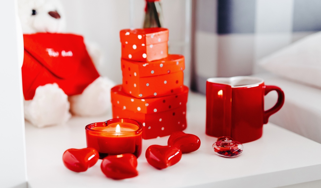 Чашка кофе на столе с подарками, зажженными свечами и сердечками