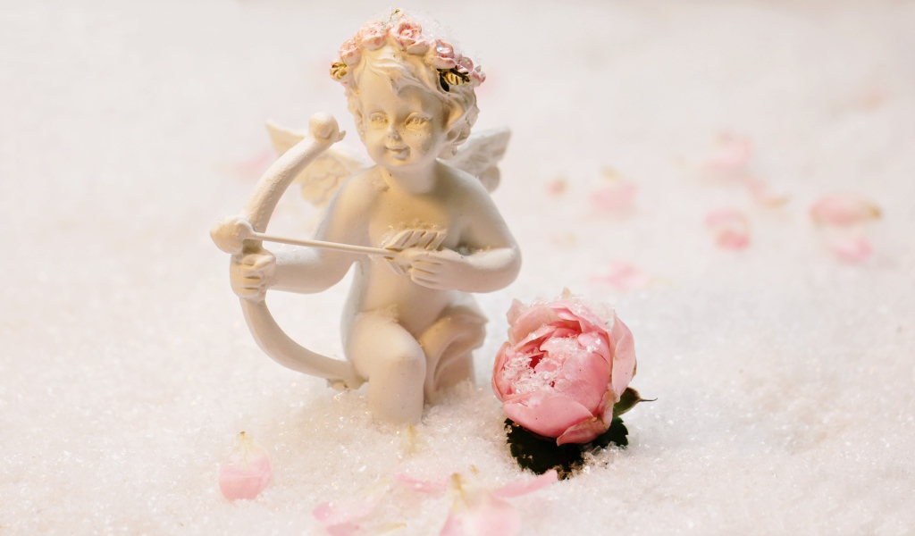 Статуэтка купидона с розой на снегу