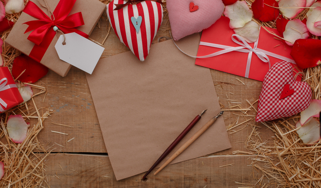 Сердечки из ткани на столе с бумагой и подарками 