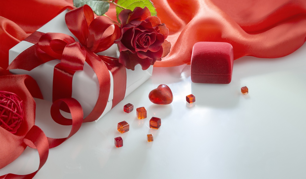 Gifts on a white table with a rose and red cloth