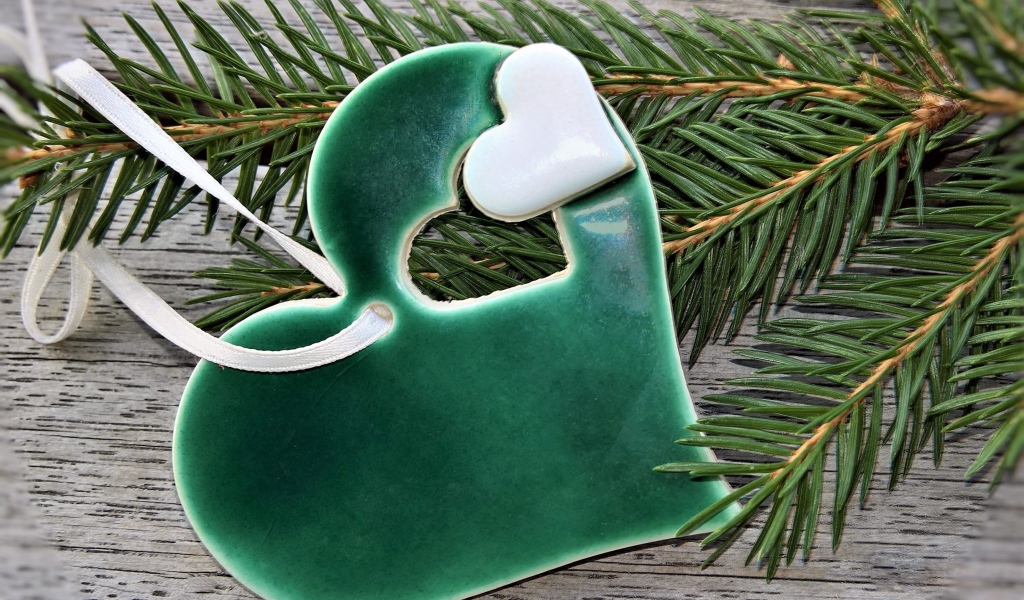 Зеленое сердце с еловой веткой на столе 