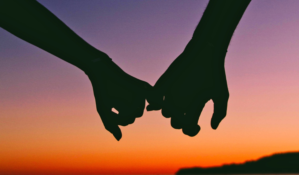 Руки влюбленной пары на закате солнца 