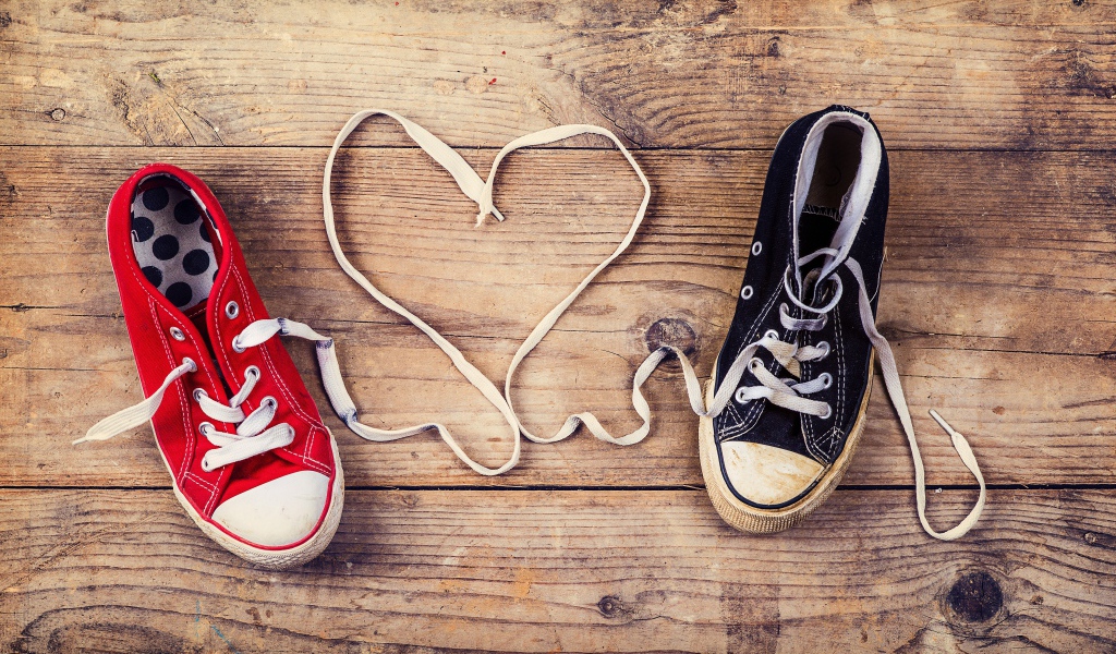 Сердце из шнурков кед на деревянном столе 