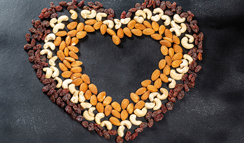 Сердце из орехов и изюма на сером фоне