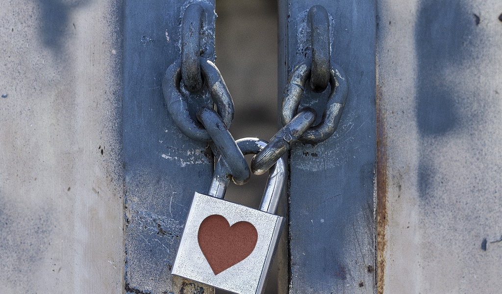 Железный замок с сердцем висит на цепи 
