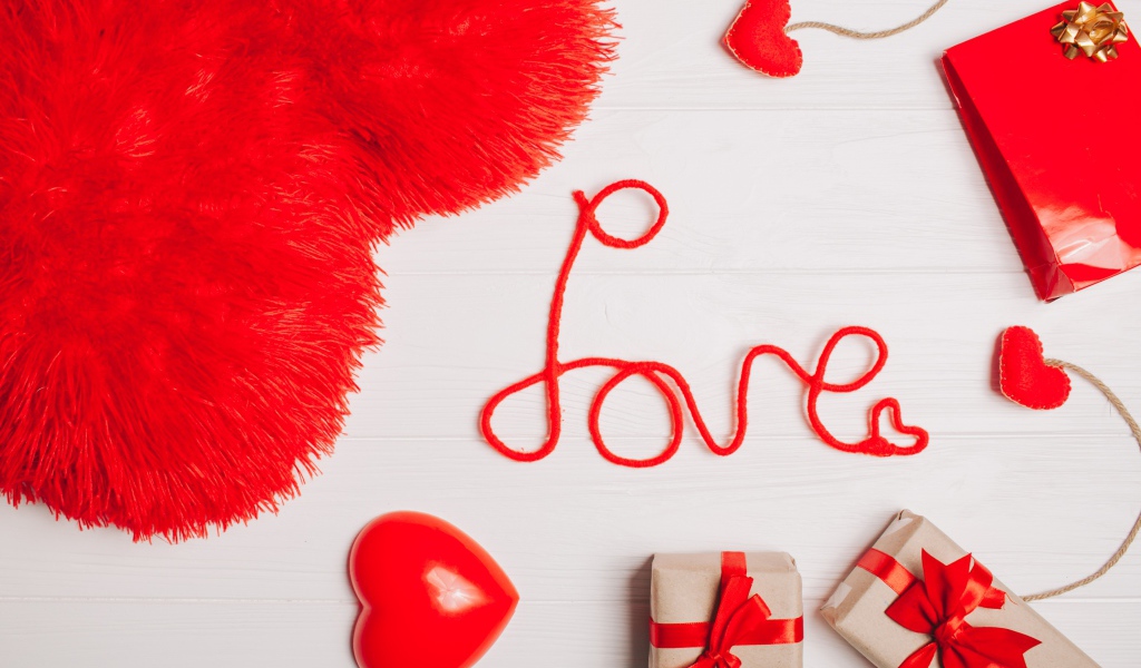 Большая подушка в форме сердца на столе с подарками 