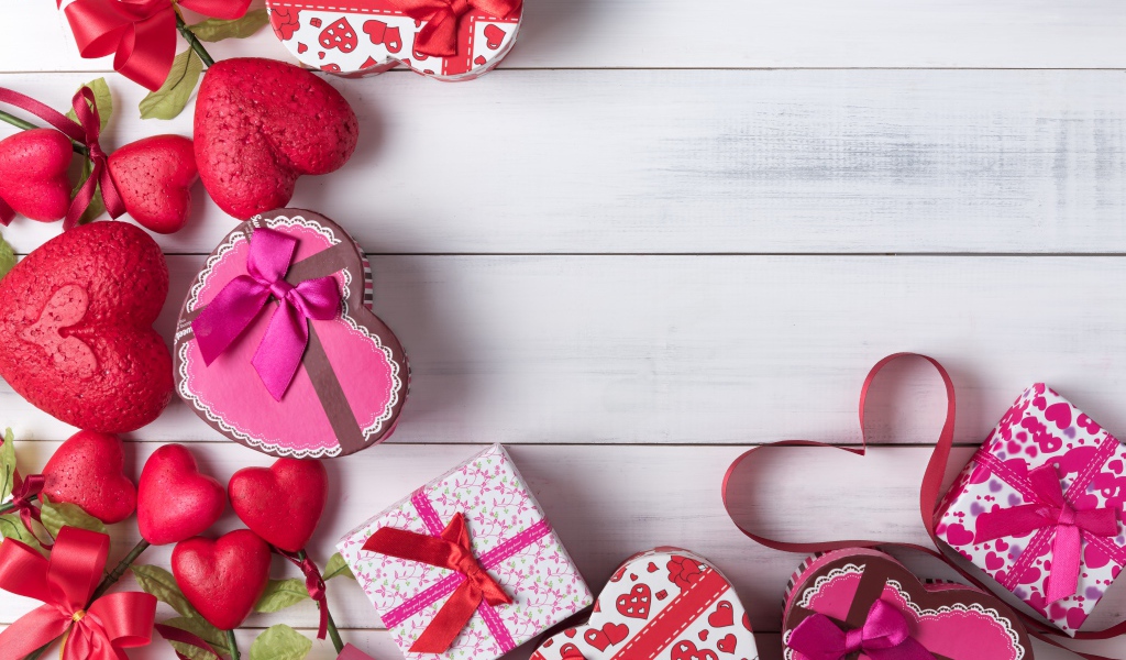 Много подарочных коробок в форме сердца на сером столе 