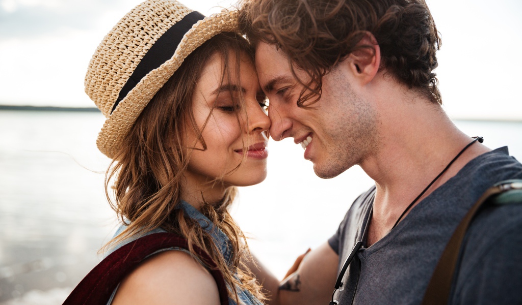 Влюбленная пара стоит на фоне моря 