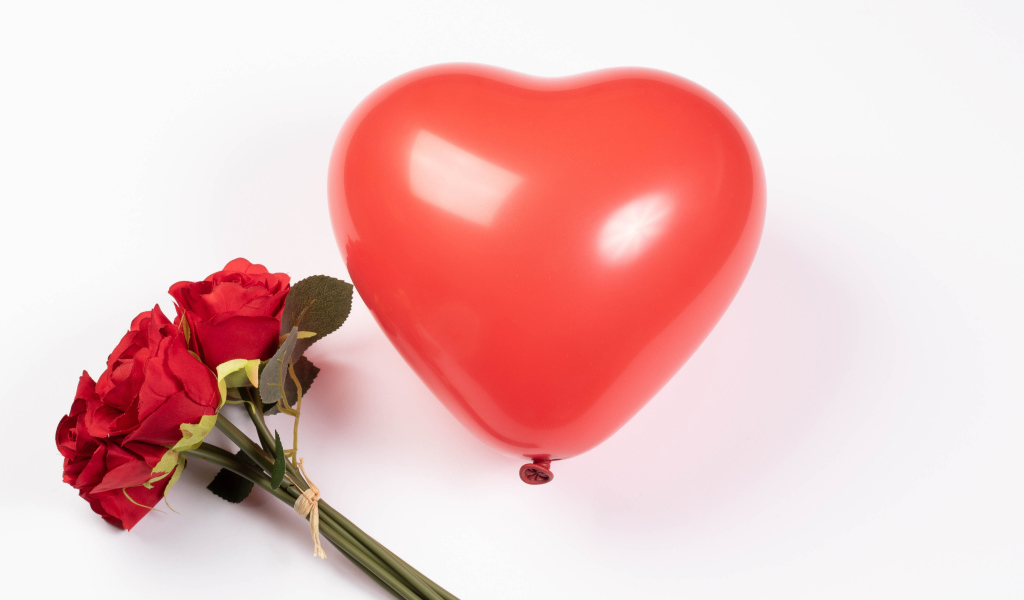 Красный шарик в форме сердца с букетом роз на белом фоне