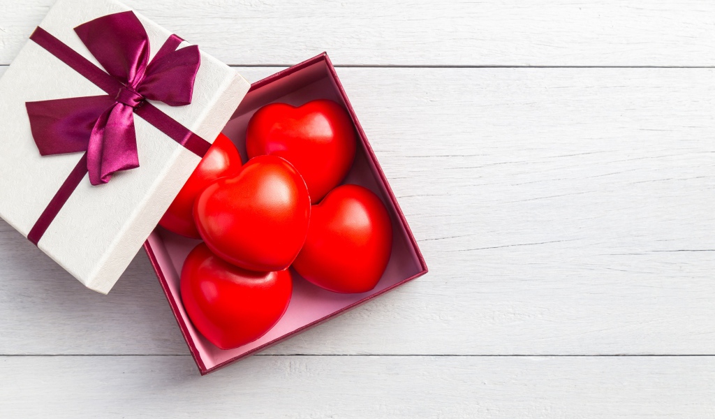 Красные сердечки в коробке на сером фоне