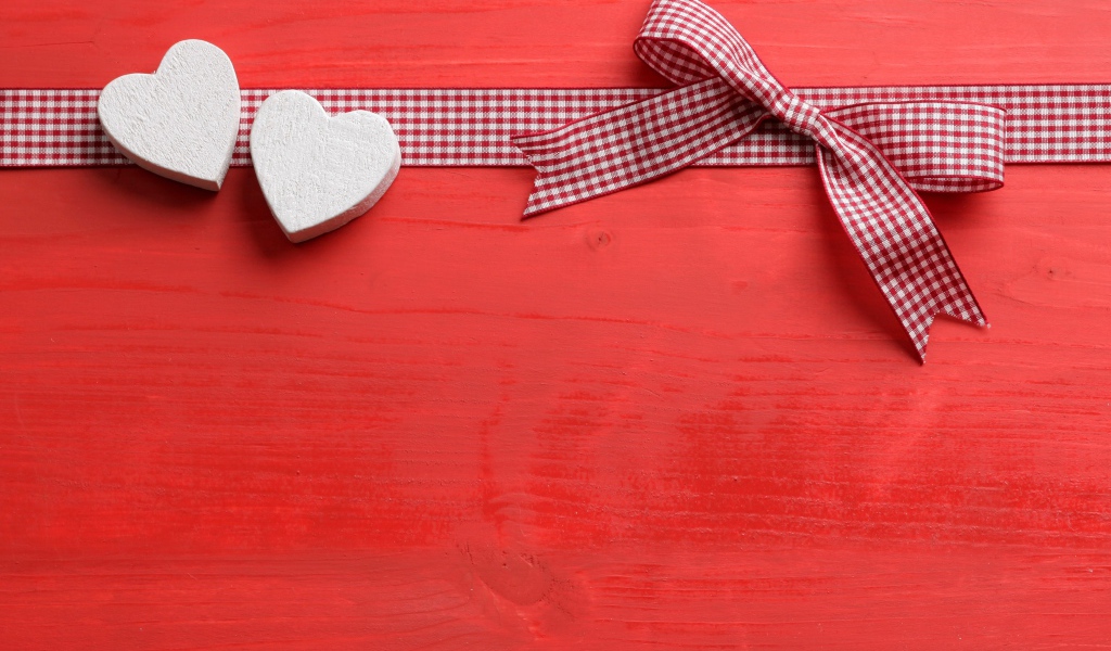 Two hearts with a bow on a red background