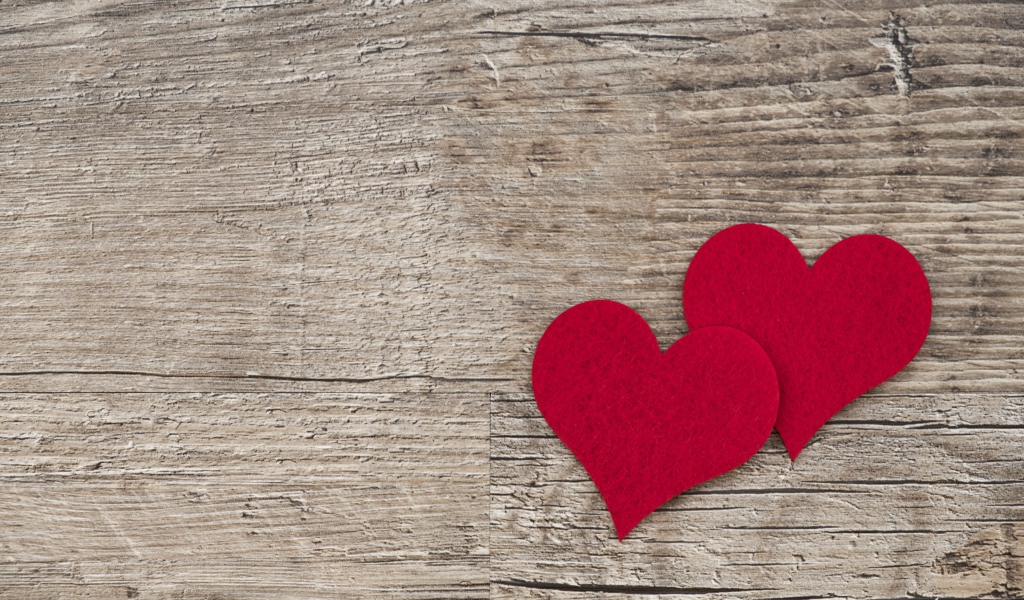 Два красных сердца на деревянном столе