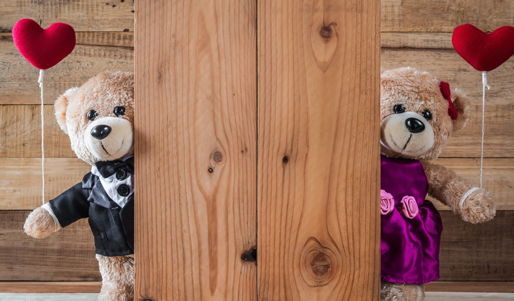 Два плюшевых медведя с сердечками у стены