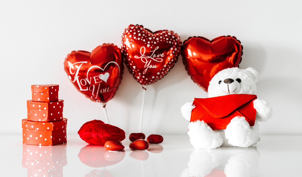 Белый мишка с подарками и шариками у стены