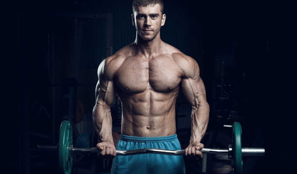Красивый накаченный мужчина со штангой в руках 