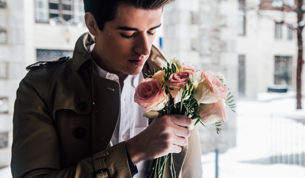 Handsome man with a bouquet of roses in his hand