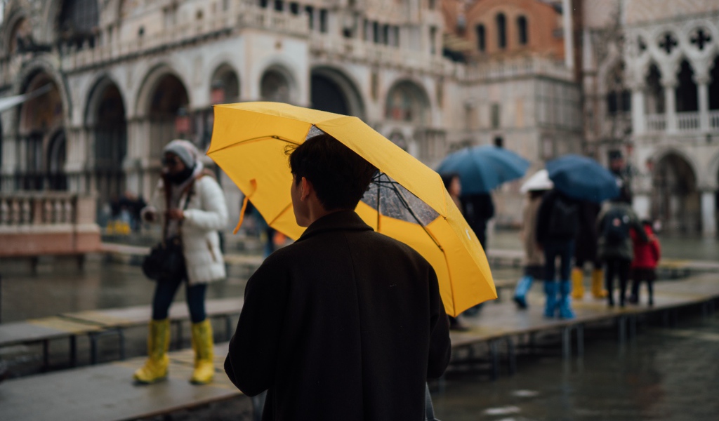 Мужчина с желтым зонтом в городе 