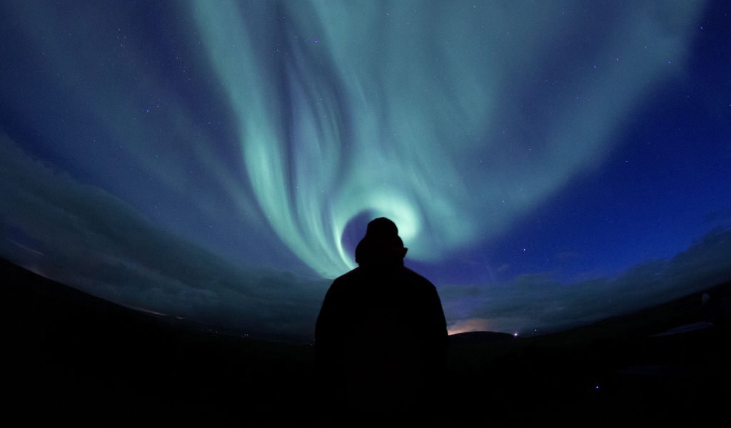 Силуэт мужчины на фоне неба с полярным сиянием
