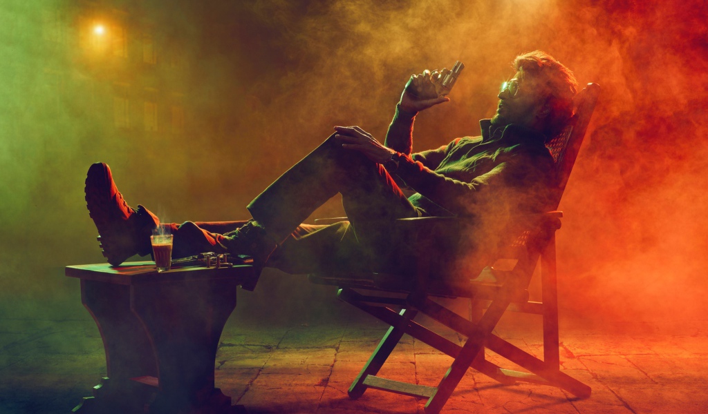 Актер болливуда Раджникант сидит в кресле