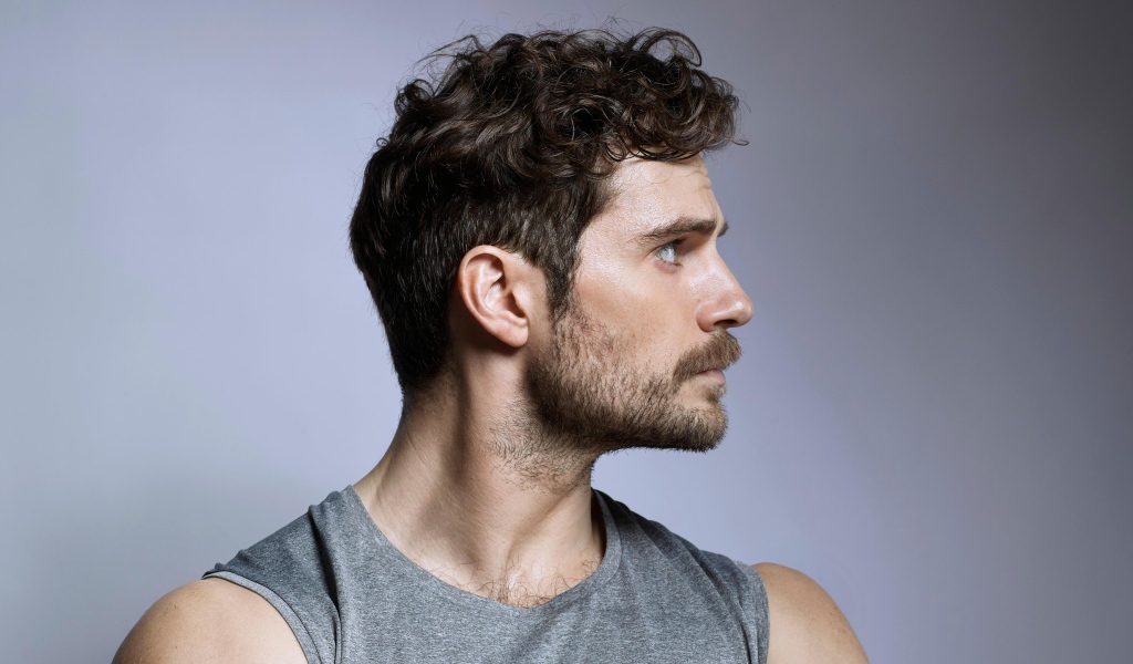 Красивый мужчина, актер Генри Кавилл на сером фоне